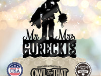 Black firefighter wedding cake topper featuring a firefighter carrying and kissing a bride holding a bouquet, with Mr and Mrs lettering and the surname GURECKIS.