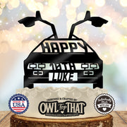 Black time machine car birthday cake topper with raised gull-wing doors, Happy lettering, personalized age 10th, and the name Luke.
