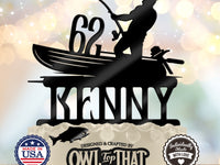 Black fishing birthday cake topper featuring an angler in a boat holding a bent fishing rod, personalized with the name Kenny and age 62.