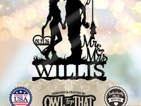 Black fishing couple wedding cake topper featuring a kissing couple holding hands, a fishing rod and fish, Mr & Mrs lettering, Willis, and a heart with 05.23.26.