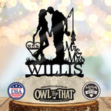Black fishing couple wedding cake topper featuring a kissing couple holding hands, a fishing rod and fish, Mr & Mrs lettering, Willis, and a heart with 05.23.26.