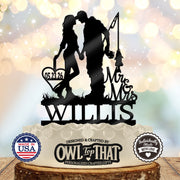 Black fishing couple wedding cake topper featuring a kissing couple holding hands, a fishing rod and fish, Mr & Mrs lettering, Willis, and a heart with 05.23.26.