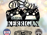 Black wedding cake topper with two game controllers, Mr and Mrs script, the date 06.07.26, and the personalized surname KERRIGAN.