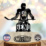 Black hockey birthday cake topper featuring a helmeted player holding a hockey stick, with number 50 on the jersey and the personalized name Geno below.