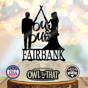 Black Jedi couple wedding cake topper featuring a bride and groom raising crossed lightsabers, Mr & Mrs script, and the personalized surname Fairbank.