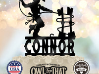 Black personalized CONNOR birthday cake topper featuring a little cowboy in a hat and boots holding a lasso beside a rustic fence.