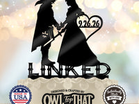 Black Link and Zelda wedding cake topper holding hands, with sword and shield details, the date 9.26.26 inside a heart, and LINKED lettering below.