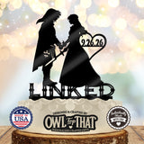 Black Link and Zelda wedding cake topper holding hands, with sword and shield details, the date 9.26.26 inside a heart, and LINKED lettering below.